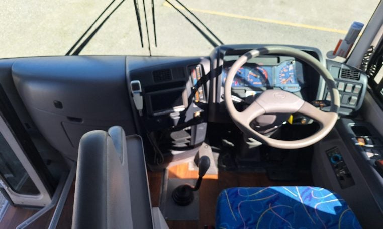 2012 Hino Melpha interior view of the driver's seat and steering wheel.