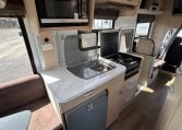 2015 Kea Horizon M721 interior view showing the central kitchen with microwave and stove.