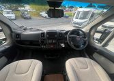 Cab and dashboard of the 2017 Auto-Trail Tribute 625 motorhome showing driver and passenger seats with controls and steering wheel.