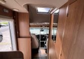 2017 Auto-Trail Tribute 625 motorhome interior showing ladder leading to over-cab bed, compact RV sleeping area with easy access