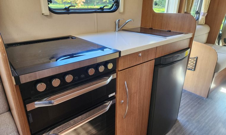 2018 Auto-Trail Imala 720 motorhome interior view of the kitchen showcasing the hobb, oven and fridge.