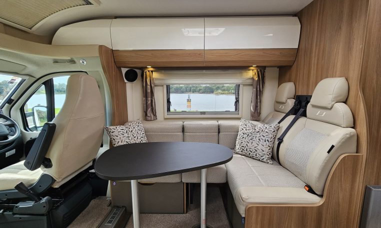 Front dining area in a 2018 Bailey Autograph 79-4T motorhome with seating and table.