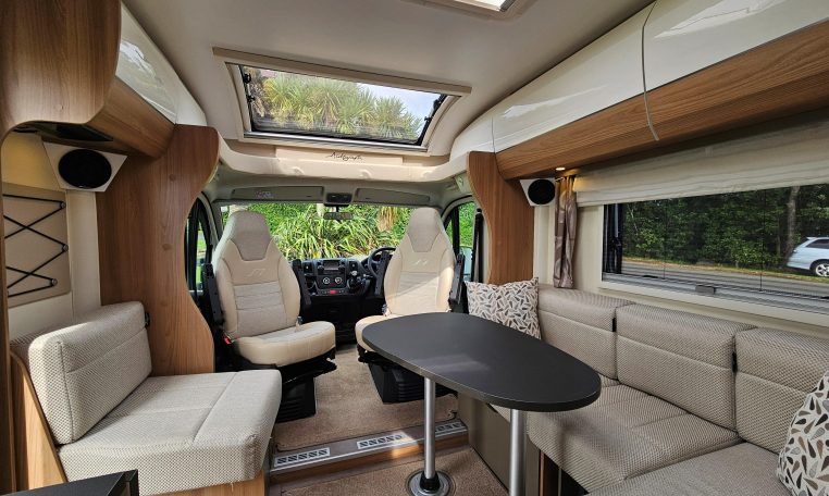 Interior view of the 2018 Bailey Autograph 79-4T motorhome living area with seating and table.