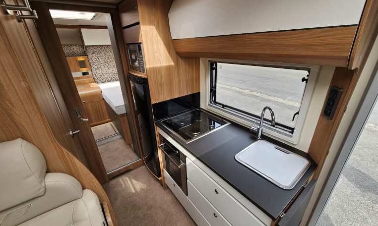 Compact 2018 Bailey Autograph 79-4T motorhome kitchen with fridge, oven and smart storage cupboards.