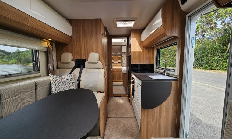 Interior view of the 2018 Bailey Autograph 79-4T motorhome living area with seating and table.