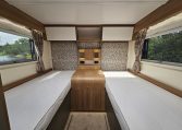 Twin single beds in a 2018 Bailey Autograph 79-4T motorhome bedroom layout, offering easy access and generous storage solutions.