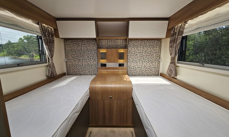 Twin single beds in a 2018 Bailey Autograph 79-4T motorhome bedroom layout, offering easy access and generous storage solutions.