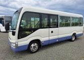 Exterior view of a Toyota Coaster bus passenger entry door used for boarding and exiting.