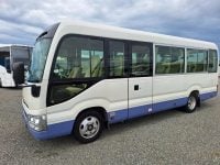 Exterior view of a Toyota Coaster bus passenger entry door used for boarding and exiting.