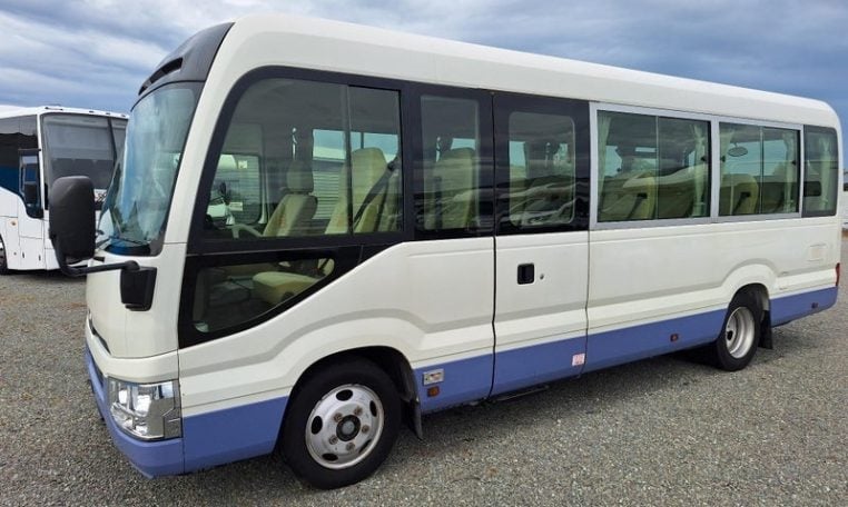 Exterior view of a Toyota Coaster bus passenger entry door used for boarding and exiting.