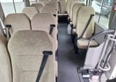 Passenger seats inside a Toyota Coaster bus arranged in rows along the aisle.
