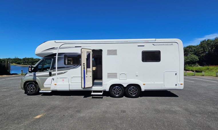 Side view of an Auto-Trail Frontier Comanche motorhome showing the habitation door and camper exterior.