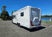 Rear side view of an Auto-Trail Frontier Comanche motorhome showing the habitation door and camper exterior.
