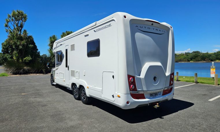 Rear side view of an Auto-Trail Frontier Comanche motorhome showing the habitation door and camper exterior.