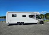 Side view of an Auto-Trail Frontier Comanche motorhome showing the driver's door and camper exterior.