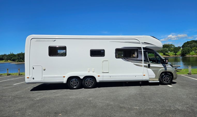 Side view of an Auto-Trail Frontier Comanche motorhome showing the driver's door and camper exterior.