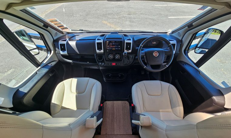 Interior view of the Auto-Trail Frontier Comanche motorhome cab with dashboard, seating, and controls.
