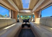 Bright Auto-Trail Frontier Comanche motorhome front lounge area with comfortable seating, swivel cab seats, and large windows.