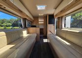 Interior view of the Auto-Trail Frontier Comanche motorhome looking from the front towards the rear, showing kitchen and lounge layout.