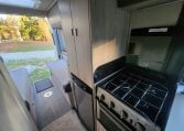2021 Auto-Trail Tribute T680 motorhome interior view of the kitchen showing the oven and fridge.