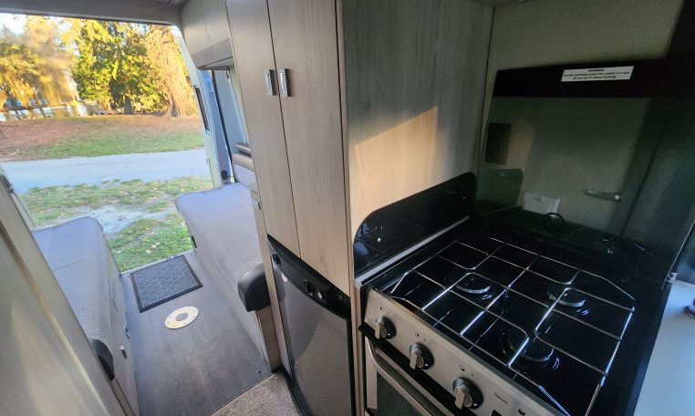 2021 Auto-Trail Tribute T680 motorhome interior view of the kitchen showing the oven and fridge.