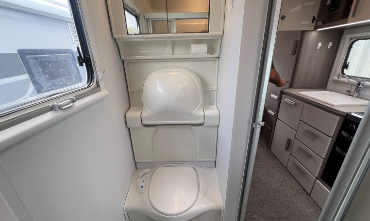 2021 Jayco Conquest FA24-4 interior view of the compact toilet and handbasin lifted up.