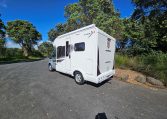 Rear-side view of the Auto-Trail F-Line F62 motorhome displaying exterior design, taillights, and habitation door.