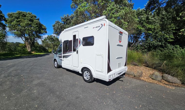 Rear-side view of the Auto-Trail F-Line F62 motorhome displaying exterior design, taillights, and habitation door.