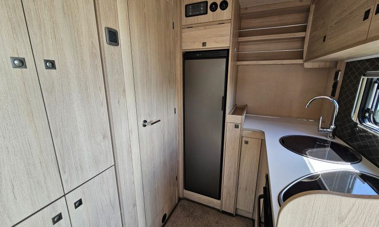 Auto-Trail F-Line F62 motorhome fridge built into the kitchen, offering convenient food storage on the road.