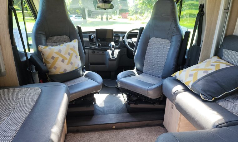 Cab swivel seats in a 2022 Auto-Trail F-Line F74 motorhome, rotating driver and passenger seats to face the living area for added comfort.