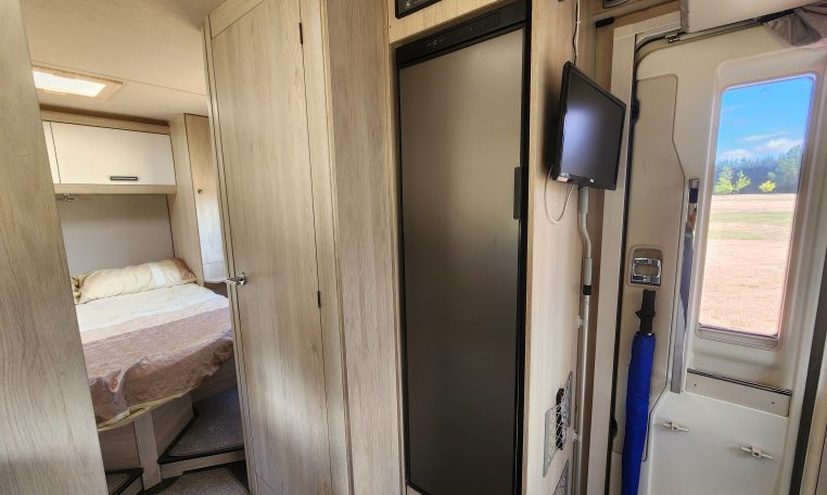 Pre-owned 2022 Auto-Trail F-Line F74 4-berth motorhome, interior view of the control panel and closed fridge.
