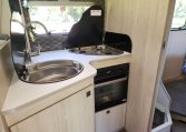 Pre-owned 2022 Auto-Trail F-Line F74 4-berth motorhome, interior view of the kitchen with the stove and oven.