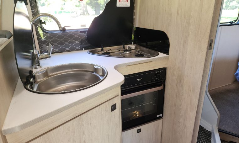 Pre-owned 2022 Auto-Trail F-Line F74 4-berth motorhome, interior view of the kitchen with the stove and oven.