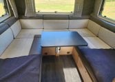 2022 Auto-Trail Tracker RL motorhome rear U-shaped lounge with dining table, spacious seating and large windows for a bright, social space.