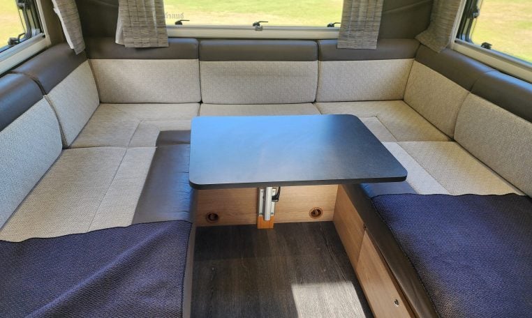2022 Auto-Trail Tracker RL motorhome rear U-shaped lounge with dining table, spacious seating and large windows for a bright, social space.