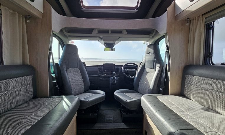2022 Auto-Trail F-Line F-60 interior showing the cab swivel seats providing extra seating in the lounge area.