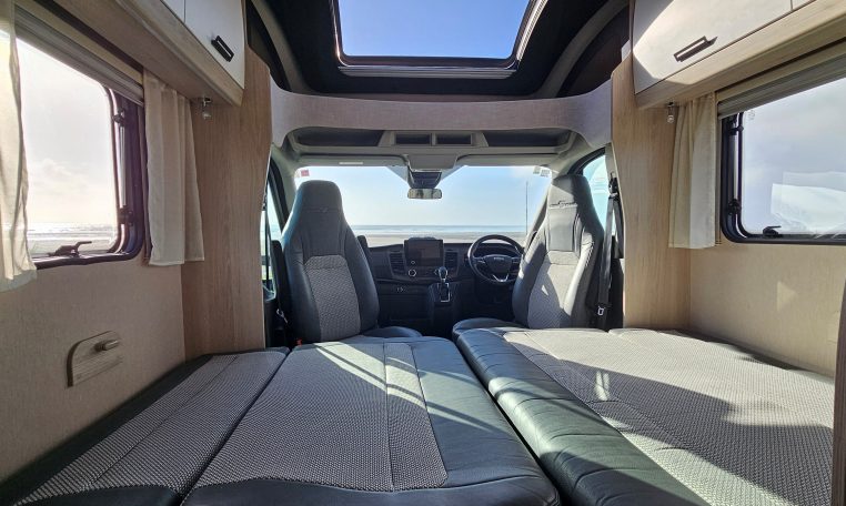 2022 Auto-Trail F-Line F-60 interior showing the front lounge converting into a bed.