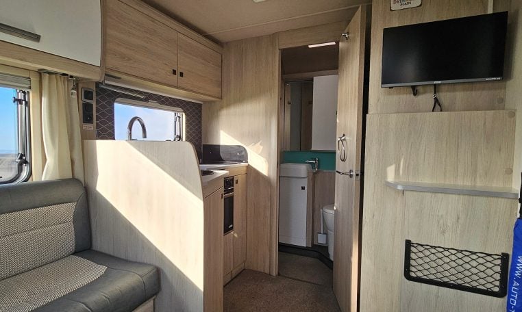 2022 Auto-Trail F-Line F-60 interior showing the TV in the front lounge.