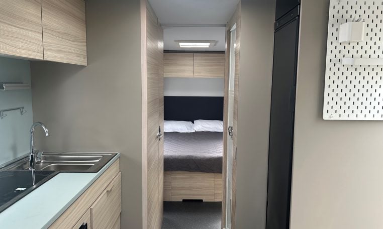 2023 Adria Altea Dart caravan interior view showing the rear bedroom from the front lounge.