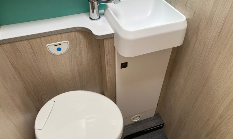 2023 Auto-Trail F74 Interior view of the bathroom with a toilet and handbasin.