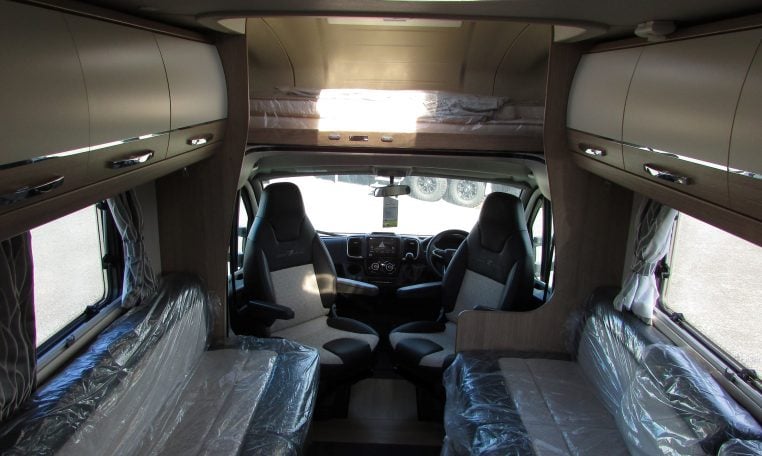 2024 Auto-Trail Frontier Comanche motorhome interior view showing the front lounge and dining overhead storage.