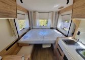 Fiat Ducato Pilote P696U interior showing the drop-down bed over the rear lounge.