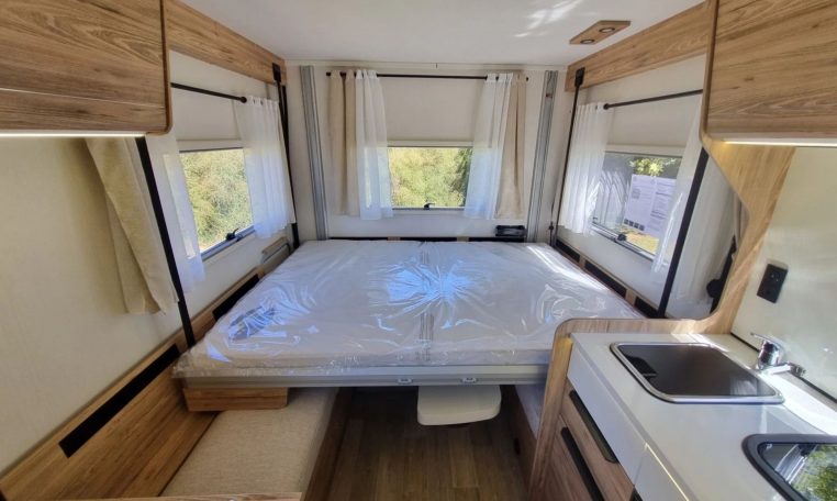 Fiat Ducato Pilote P696U interior showing the drop-down bed over the rear lounge.