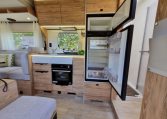 Fiat Ducato Pilote P696U interior showing the kitchen with fridge and freezer.