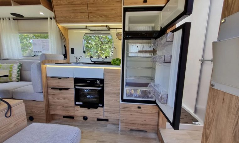Fiat Ducato Pilote P696U interior showing the kitchen with fridge and freezer.