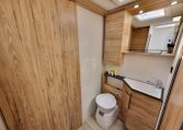 Fiat Ducato Pilote P696U interior showing the bathroom setup with toilet and handbasin.