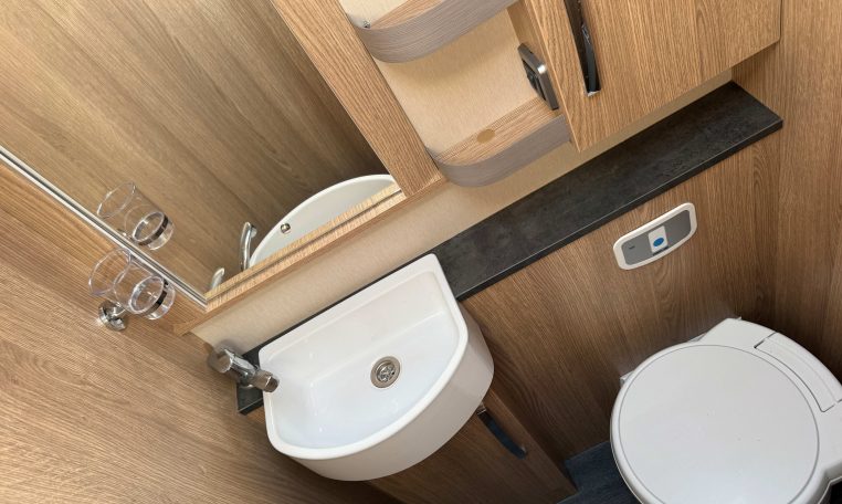 2025 Auto-Trail Frontier Comanche interior view of the toilet and handbasin in the bathroom.