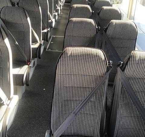 Passenger seats inside a BCI Classmaster bus arranged in rows along the aisle.
