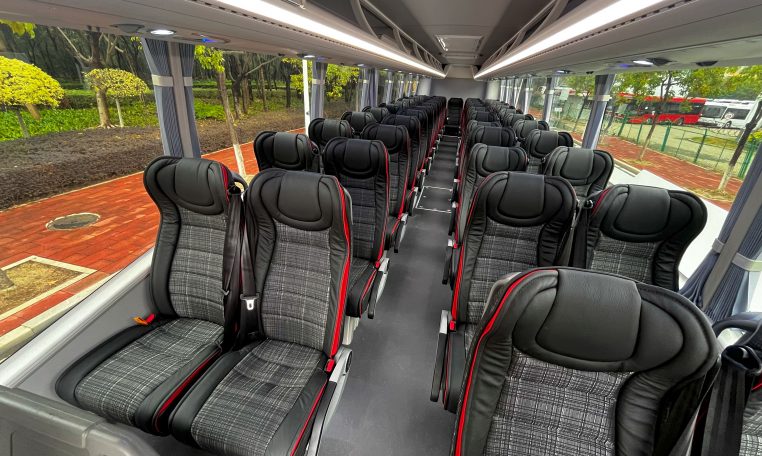 Passenger seats inside a BCI Classmaster bus arranged in rows along the aisle.