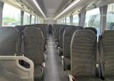 Passenger seats inside a BCI Cruiser bus arranged in rows along the aisle.